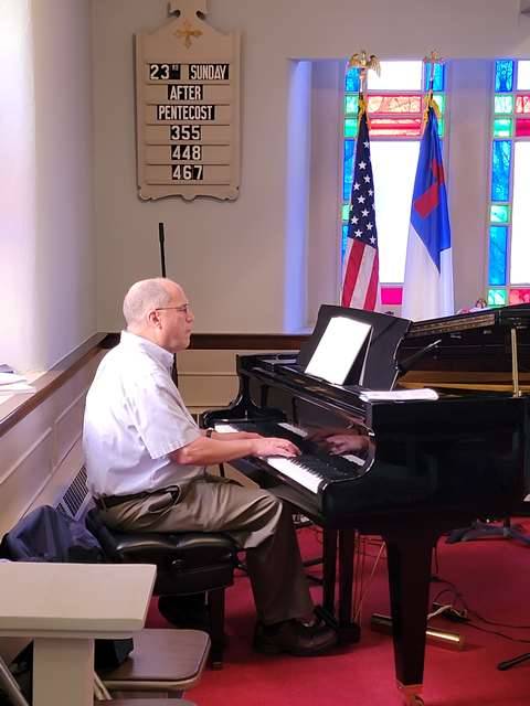 Dave Deysher playing piano in front of worship service
